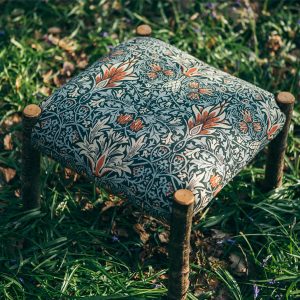 Hand made unique wooden footstool. The stool is upholstered in Arts and Crafts Designer William Morris Print. The classic Morris and Co print features repeated symmetrical patterns and nature motifs.